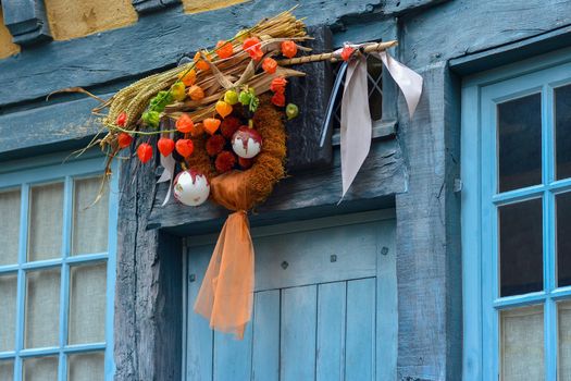 Wreath of autumn plants with physalis wheat and christmas tree toy on a blue door
