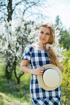 beautiful girl in a dress walking in the spring forest where the trees bloom