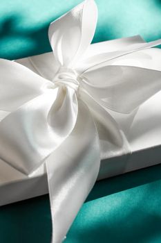 Anniversary celebration, shop sale promotion and bridal surprise concept - Luxury holiday white gift box with silk ribbon and bow on emerald green background, luxe wedding or birthday present