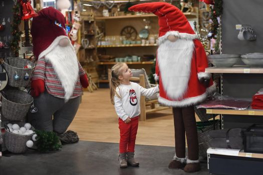 Girl looking at Santa Claus in a store with toys and decorations