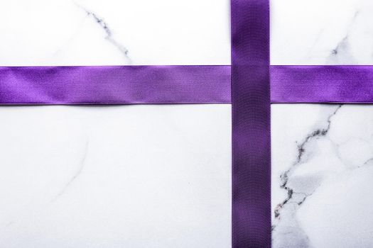 Happy holidays, festive decoration and brand sale promotion concept - Purple silk ribbon and bow on luxury marble background, holiday flatlay backdrop