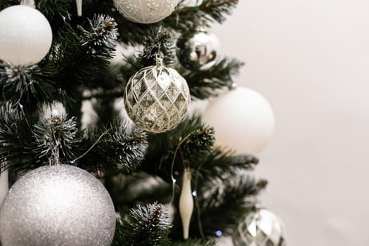 Fancy decorations on a green Christmas tree: balls, candies, pine cones. Close up photo of decorated fir tree