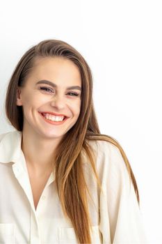 Beauty concept of woman. Portrait of a happy charming shy smiling young caucasian woman with long brown hair posing and looking at the camera over white background