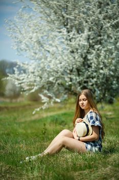 beautiful girl in a dress walking in the spring forest where the trees bloom