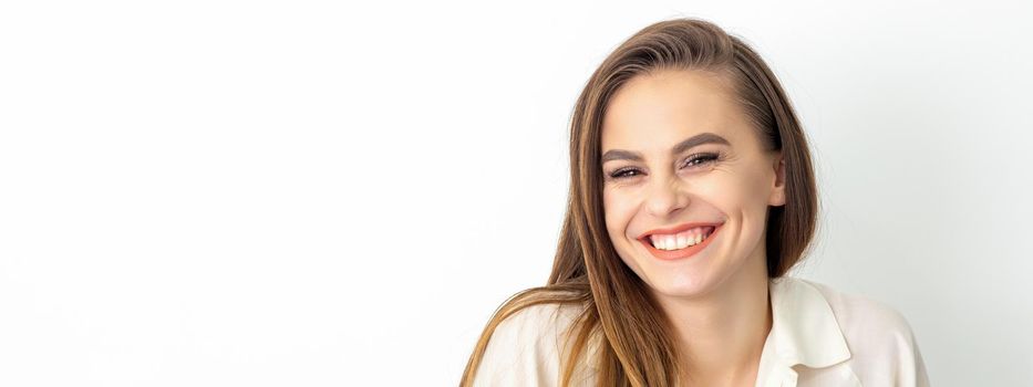 Beauty concept of woman. Portrait of a happy charming shy smiling young caucasian woman with long brown hair posing and looking at the camera over white background