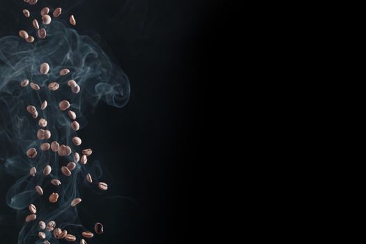 Fresh ccoffee beans in flight on a dark background whith smoke
