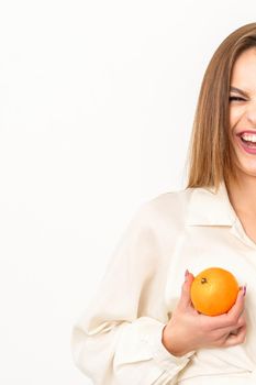 Young Caucasian smiling woman holding slices orange over isolated white background, breast health concept