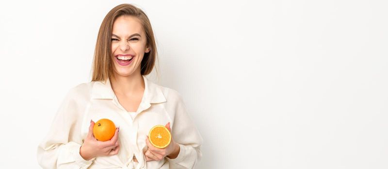 Young Caucasian smiling woman holding slices orange over isolated white background, breast health concept