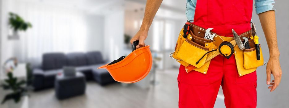 Worker with a diy tool belt over construction background