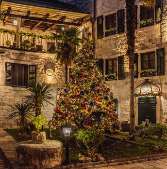 Holiday Christmas Tree Decorating with Multi Colored Lights at Night. Beautiful snowy winter scenery of Christmas holiday fair in Europe.