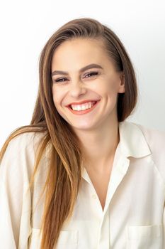 Beauty concept of woman. Portrait of a happy charming shy smiling young caucasian woman with long brown hair posing and looking at the camera over white background