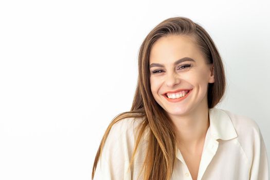 Beauty concept of woman. Portrait of a happy charming shy smiling young caucasian woman with long brown hair posing and looking at the camera over white background