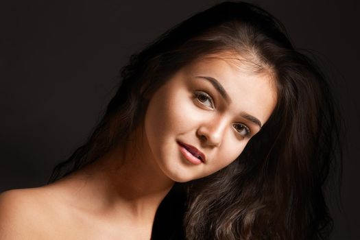 fashionable young woman in studio on dark background