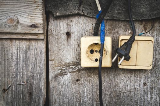 Old socket. Switch and socket. Broken electrical appliances. Non-working tool. Dangerous wires.