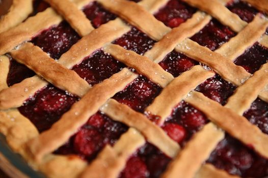 Close-up of a classic American cherry pie with crispy sweet pastry lattice. Homemade festive cherry cake with a flaky crust. Thanksgiving concept. Bakery products