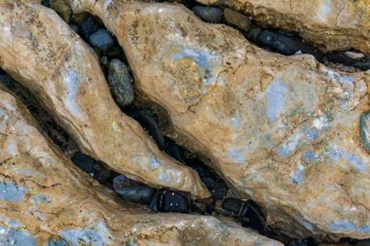 Small stones in the crevices of rocks. Stone background