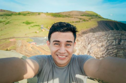 Adventurous man taking a selfie at a viewpoint. Close up of person taking an adventure selfie, Tourist taking a selfie at a viewpoint. Handsome tourist taking a selfie on vacation