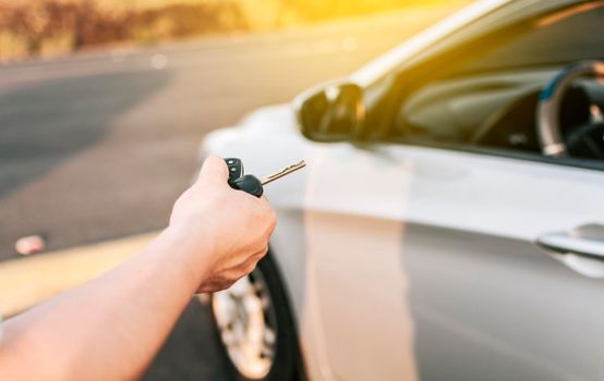 Close-up of driver outside car holding keys. Driver hands showing the car keys, Driver hands showing the keys outside the vehicle, Vehicle rental concept