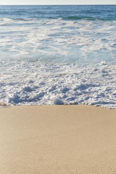 Ocean waves with white foam on a sunny day background