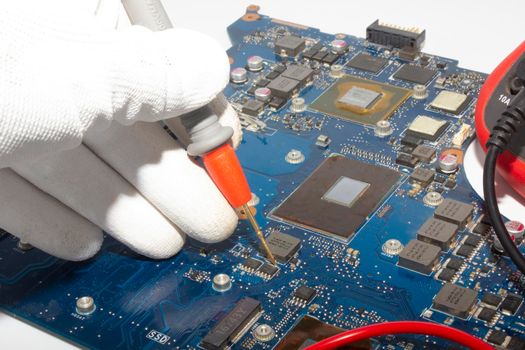 Computer repair service. Engineer repairing laptop mainboard. Hardware developer measure electronic components. 