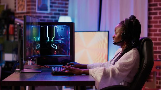 African american gamer girl streaming online first person shooter action game surprised after winning online competition on gaming pc. Woman has success in first person shooter multiplayer tournament.