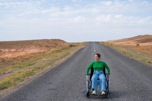 Woman in a wheelchair on a highway in the steppes