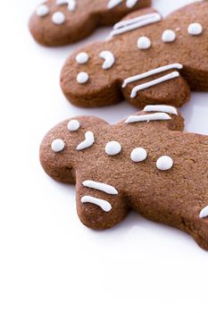 Homemade gingerbread cookies decorated with white icing on white background.