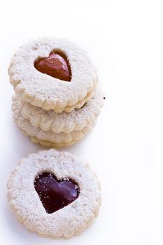 Linzer Torte cookies on white background with powdered sugar sprinkled on top.