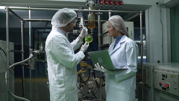 Two scientist in professional uniform working in laboratory for chemical and biomedical experiment