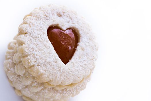 Linzer Torte cookies on white background with powdered sugar sprinkled on top.