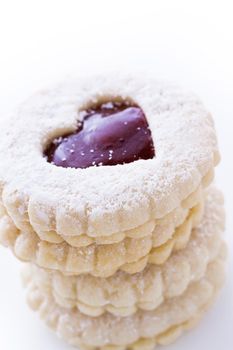 Linzer Torte cookies on white background with powdered sugar sprinkled on top.