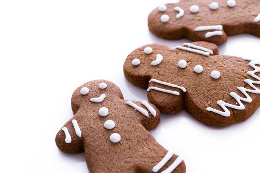 Homemade gingerbread cookies decorated with white icing on white background.