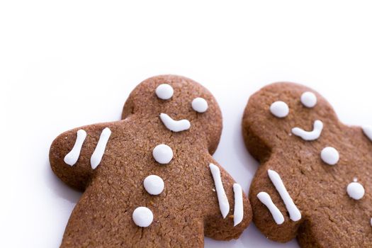 Homemade gingerbread cookies decorated with white icing on white background.