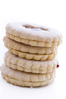 Linzer Torte cookies on white background with powdered sugar sprinkled on top.