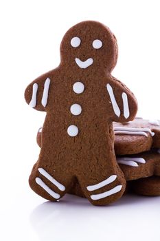 Homemade gingerbread cookies decorated with white icing on white background.