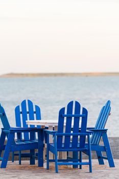 Pation with blue furniture on the beach.