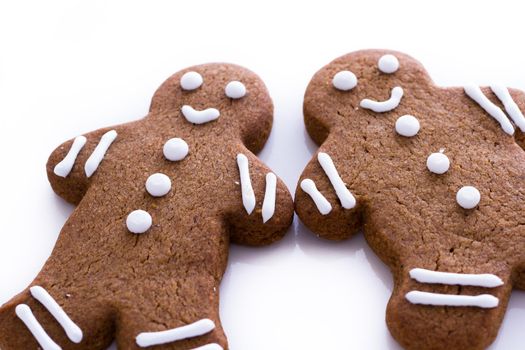 Homemade gingerbread cookies decorated with white icing on white background.