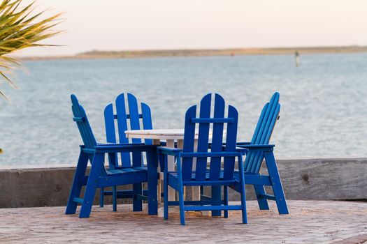 Pation with blue furniture on the beach.