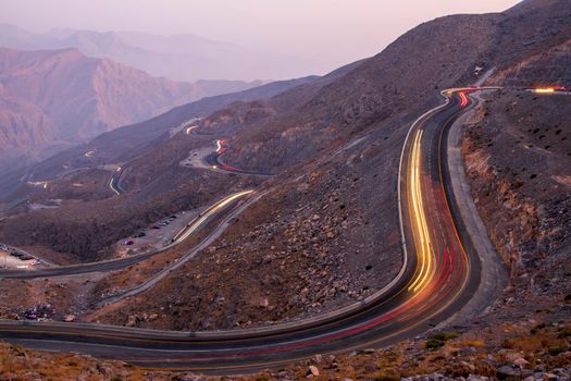 View from Jebael Jais mountain of Ras Al Khaimah emirate in the evening. United Arab Emirates, Outdoors. Light trails from the car