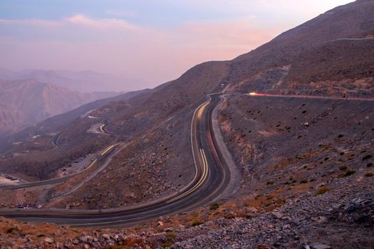 View from Jebael Jais mountain of Ras Al Khaimah emirate in the evening. United Arab Emirates, Outdoors. Light trails from the car