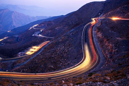 View from Jebael Jais mountain of Ras Al Khaimah emirate in the evening. United Arab Emirates, Outdoors. Light trails from the car