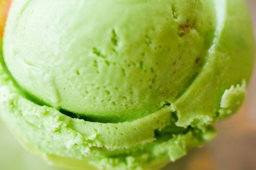 Green gelato in green plastic cup.