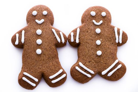 Homemade gingerbread cookies decorated with white icing on white background.