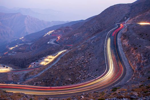 View from Jebael Jais mountain of Ras Al Khaimah emirate in the evening. United Arab Emirates, Outdoors. Light trails from the car