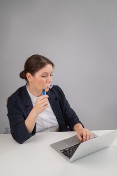 Business woman smoking a disposable vape while sitting at her desk