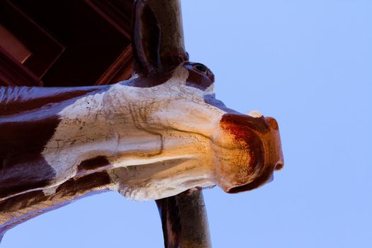 Sculpture of texas longhorn on building exterior.