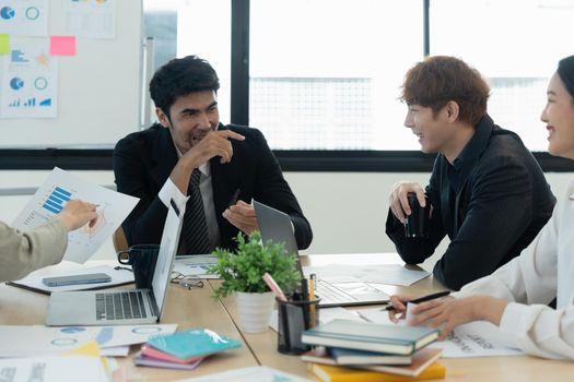 Business people diverse discussing while laughing in meeting, working for financial paperwork with laptop computer.