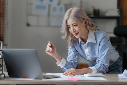 Asian Business woman working to analyze technical price graph and indicator. finance concept.