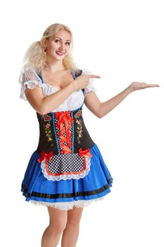 Beautiful young blond girl in dirndl drinks out of oktoberfest beer stein. Isolated on white background. pointing finger and smiling. copyspace desing concept