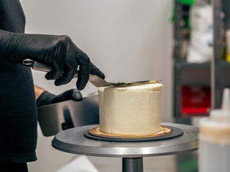 professional baker decorating a chocolate and cream cake with salty caramel